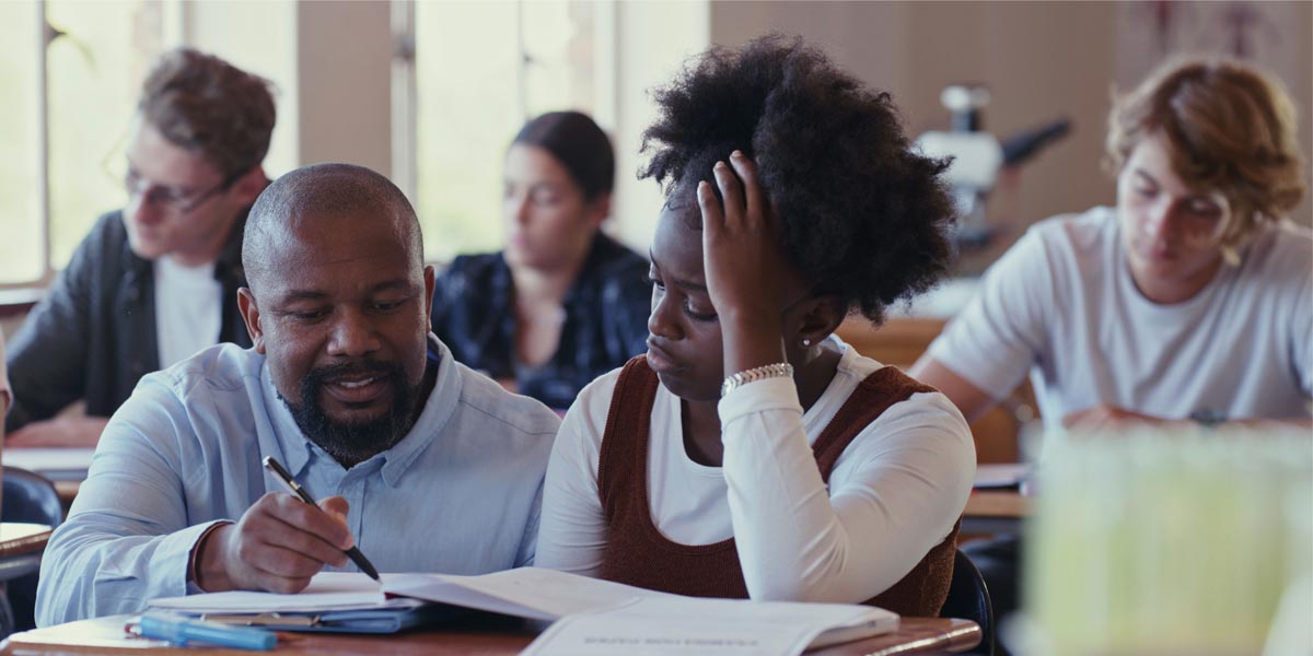 teacher helping a student in a classroom