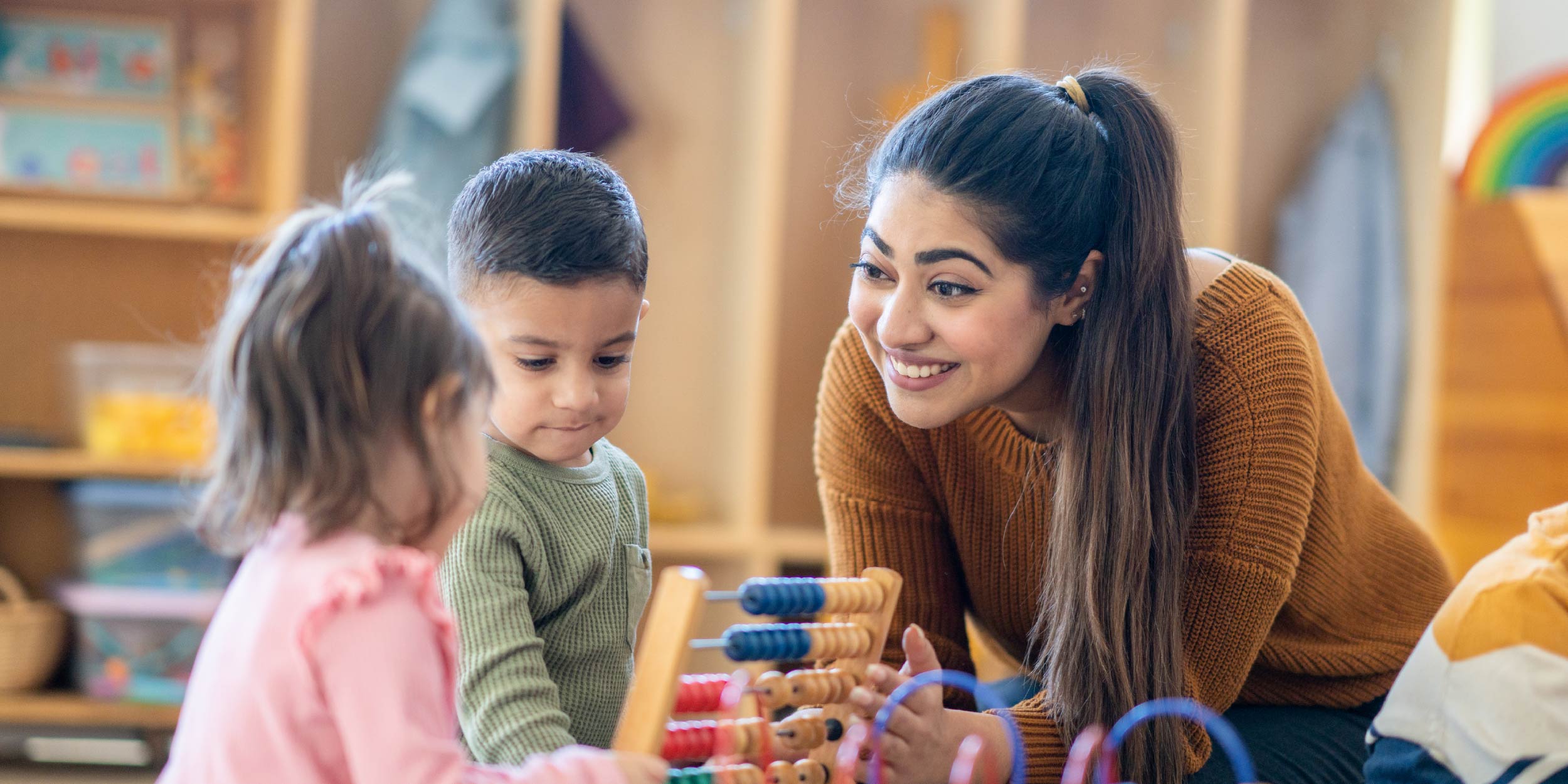 A teacher helping a preschool student