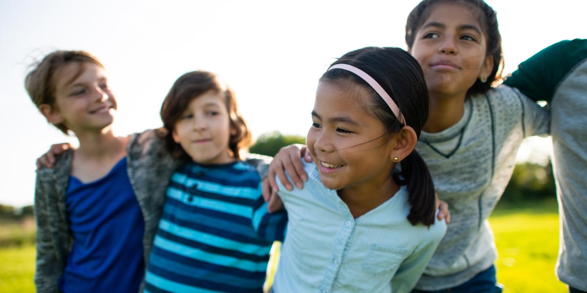 four young children embracing