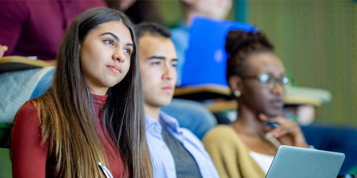 three students listening to a lecture