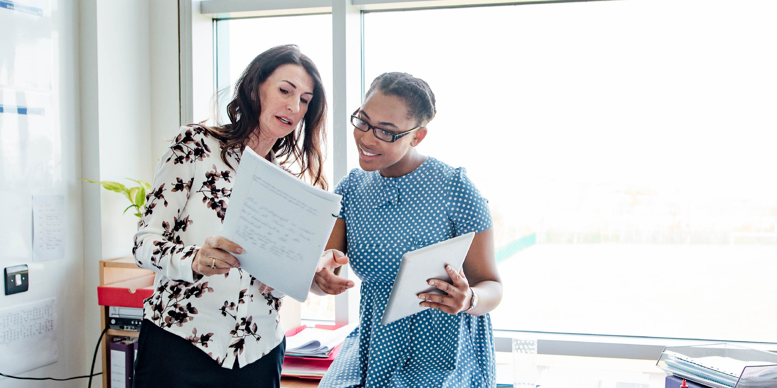 Two teachers looking at a piece of paper and talking