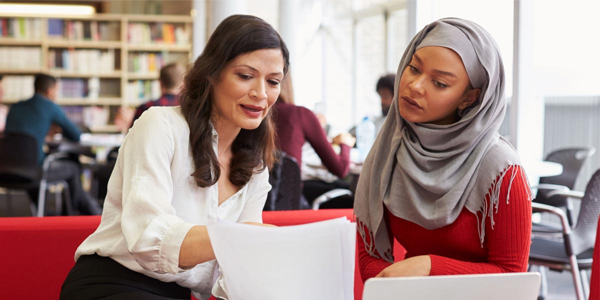 teacher helping a student in a classroom