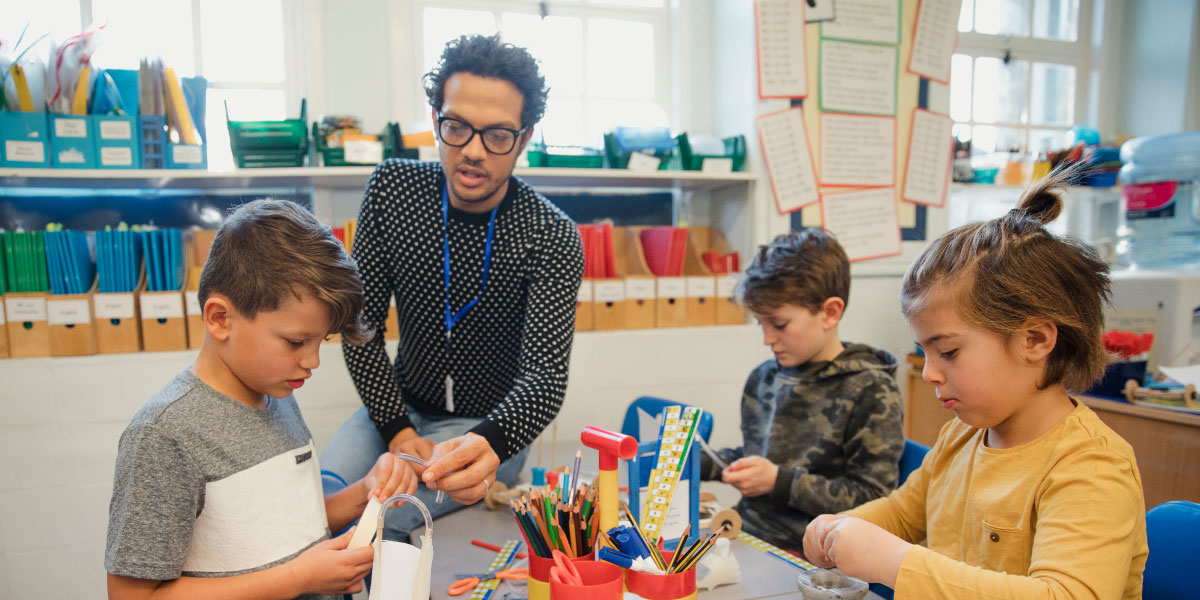 A teacher helping a students on a science project