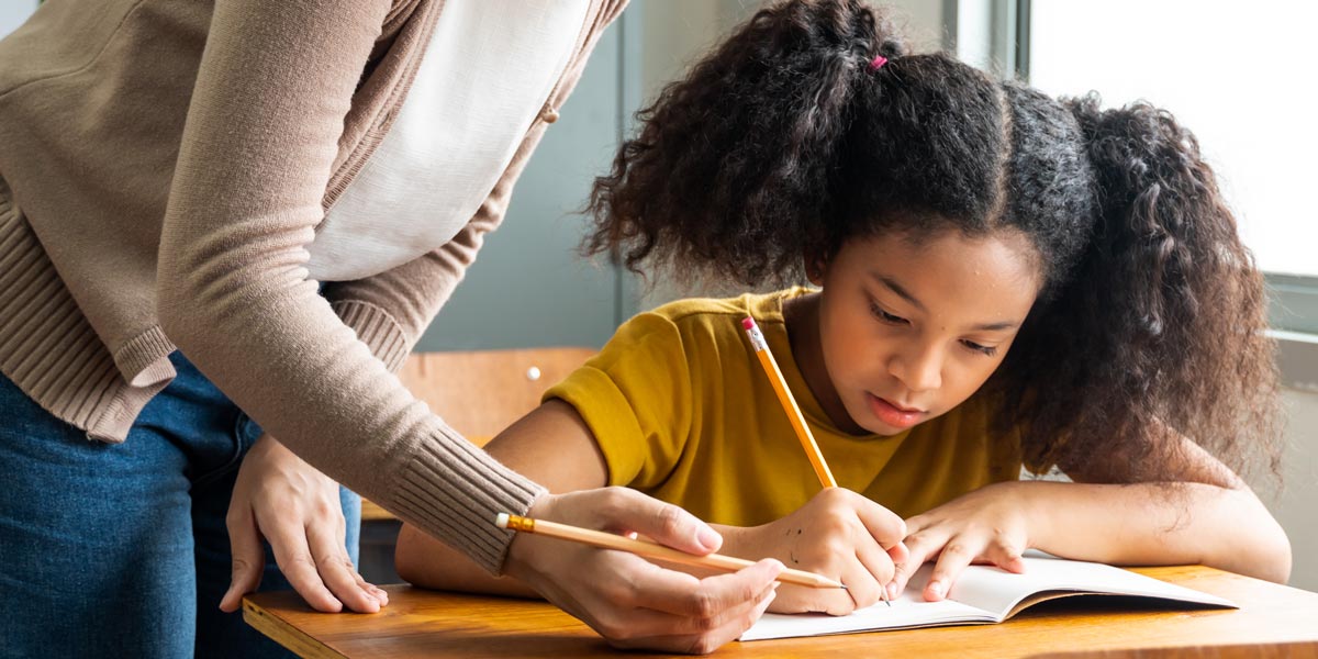 student writing with a pencil