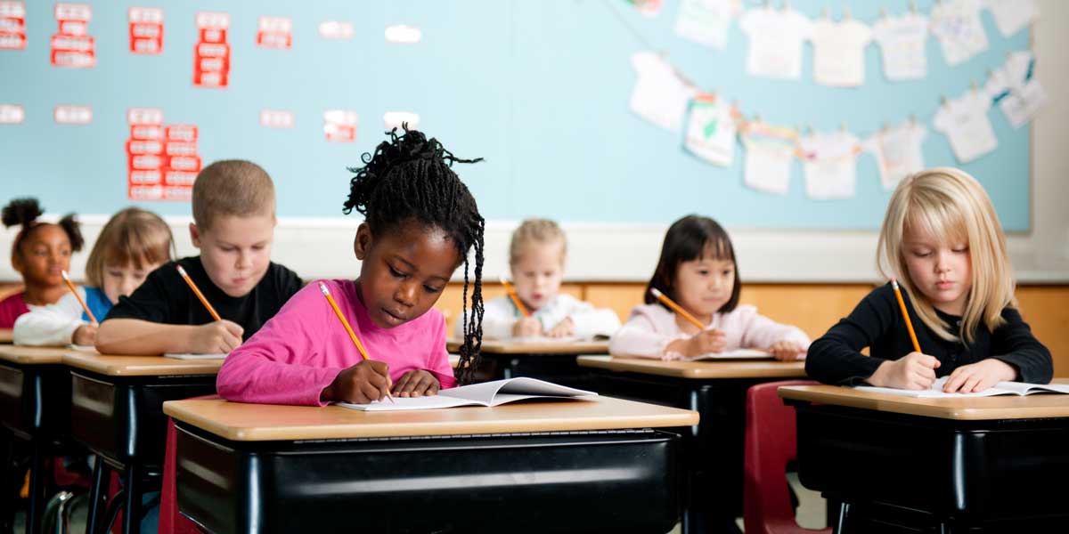 young students writing in a classroom