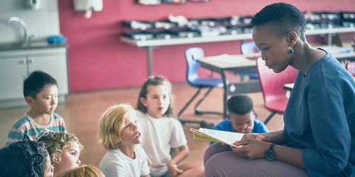 teacher reading to students in a classroom