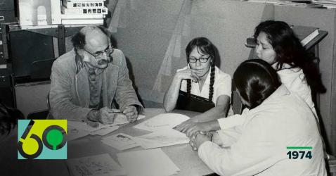 black and white photo of a group in a meeting at a table