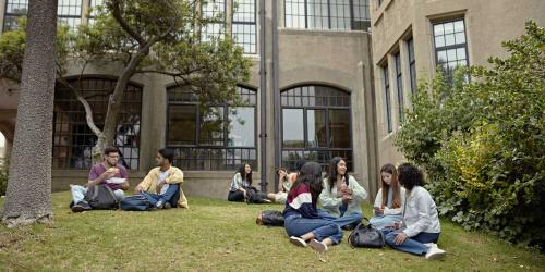college students hanging out in front of a building